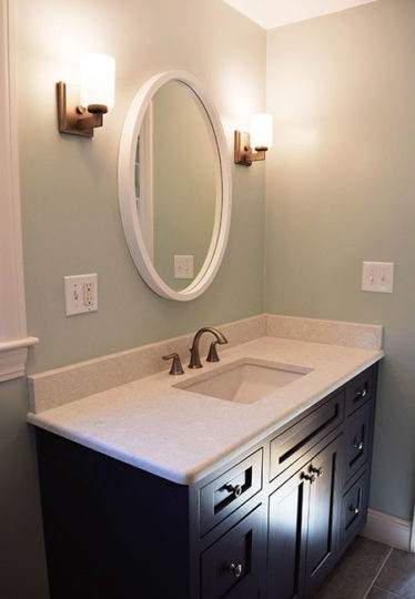 Newly installed custom cabinetry in Gunmetal Gray with a Ciatera Cirrus vanity top